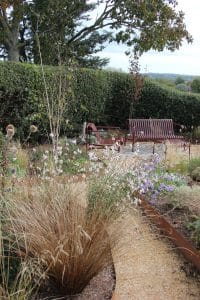 yellow gravel garden path and red metal chairs